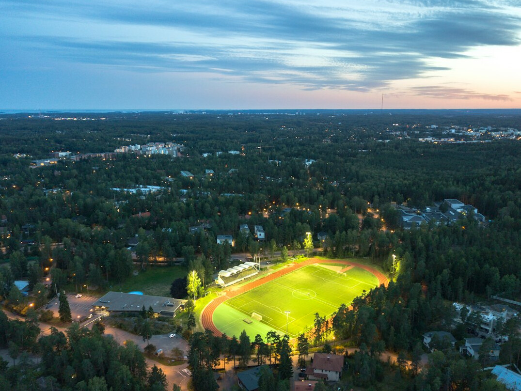 Football stadium under floodlights at dusk